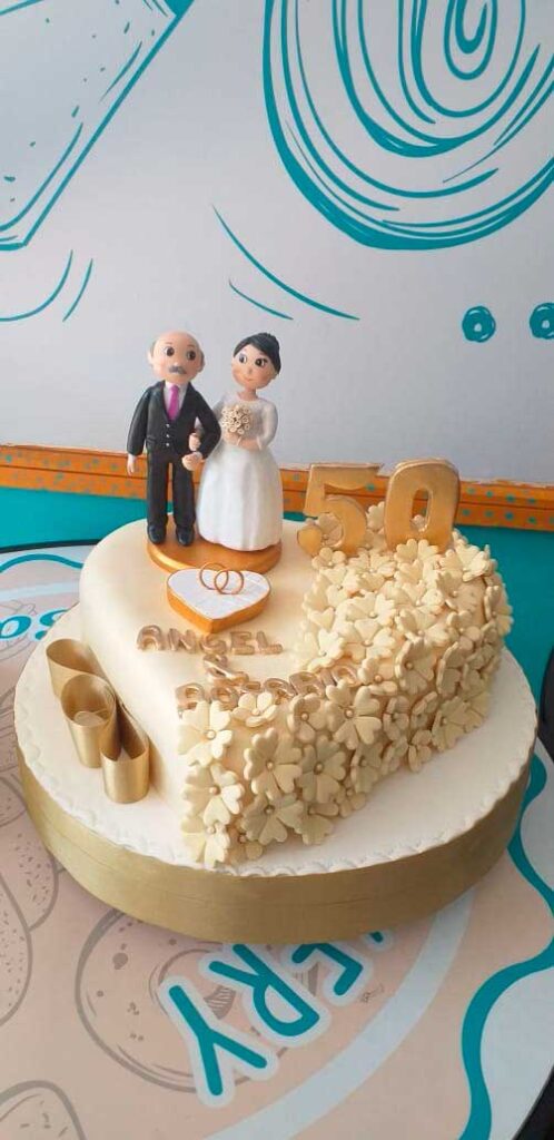 Torta de pareja celebrando sus 50 años juntos con flores en fondant curuba.